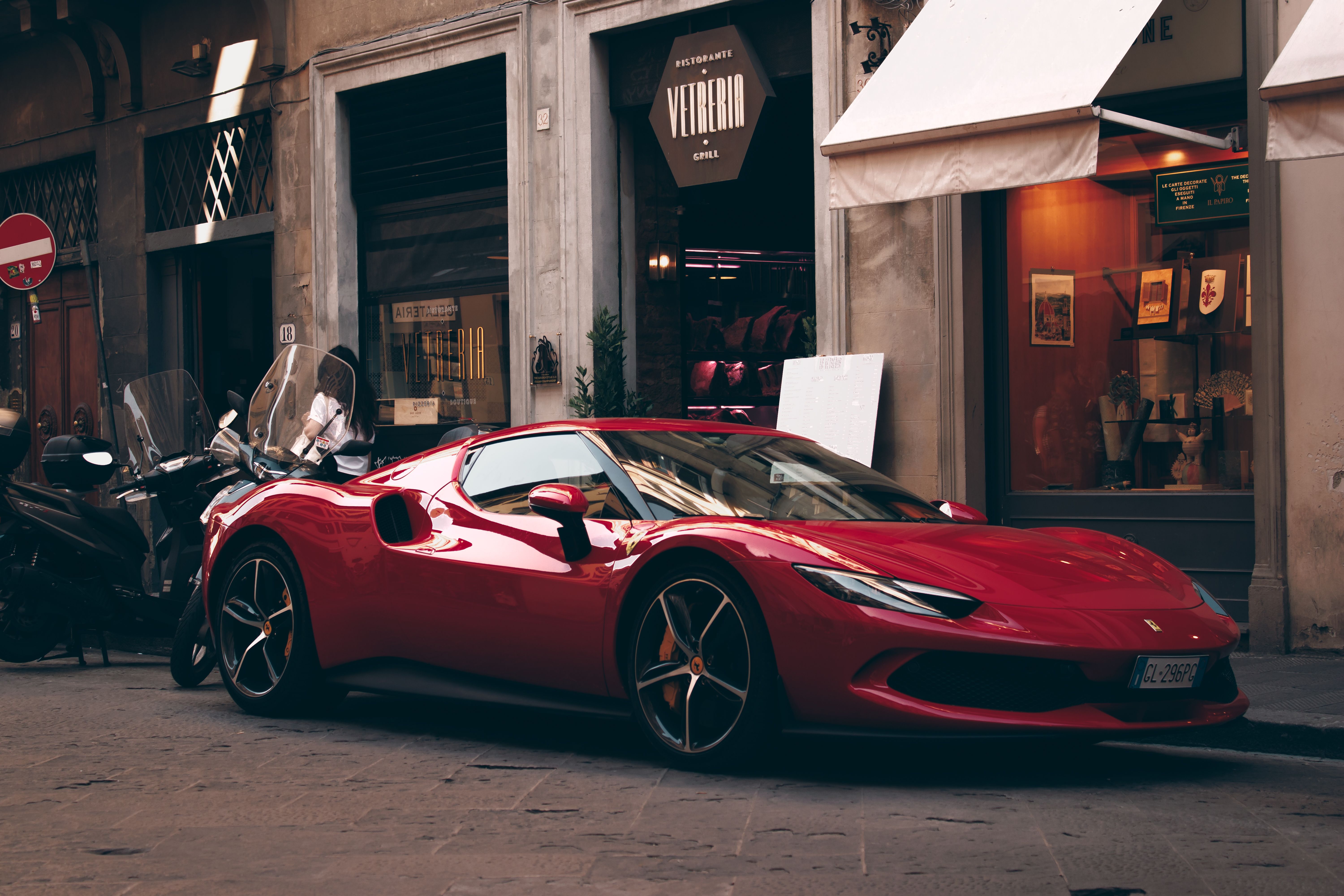 A red Ferrari parked on an Italian street